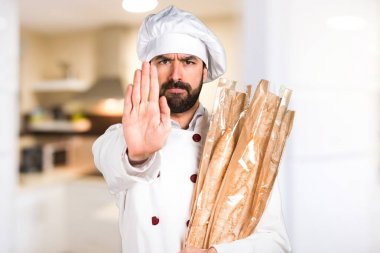 Biraz ekmek tutan ve mutfakta dur işareti yaparak genç baker