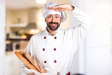 Biraz ekmek tutan ve bir şey mutfakta gösterilen genç baker