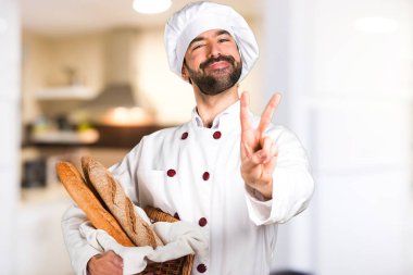 Biraz ekmek ve verme zafer jest mutfakta tutan genç baker