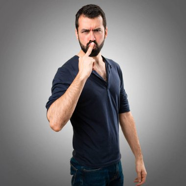 Sakal yapma boynuz jest gri arka plan üzerinde olan yakışıklı adam