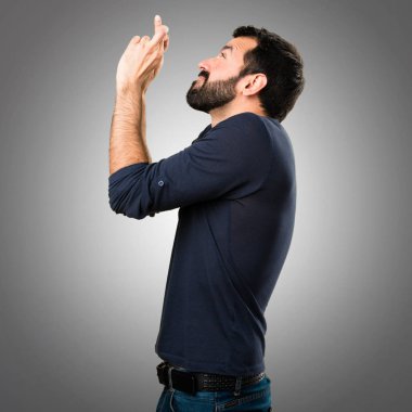 Üzerinde gri backgr geçiş parmaklarıyla sakallı yakışıklı adam