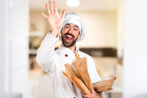Unga bagare håller vissa bröd och salutera i köket — Stockfoto