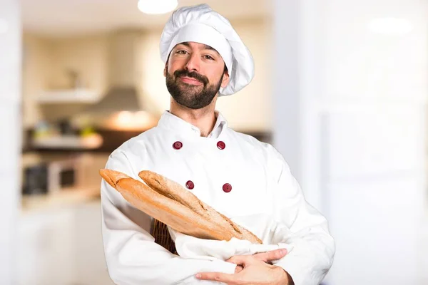 Fiatal baker gazdaság kenyeret, a konyhában — Stock Fotó