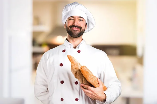 台所でいくつかのパンを持って若いベイカー — ストック写真