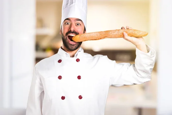 Galna unga bagare håller vissa bröd i köket — Stockfoto