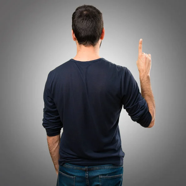 Hombre guapo con barba contando uno sobre fondo gris —  Fotos de Stock