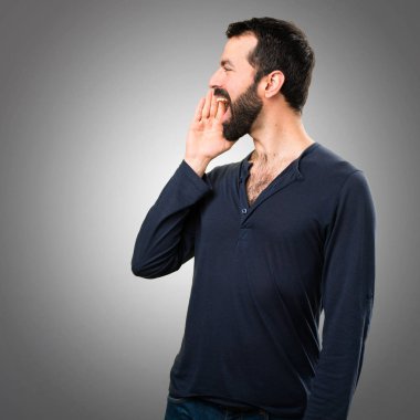 Gri arka plan üzerine bağırarak sakallı yakışıklı adam