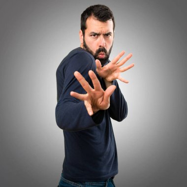 Gri arka plan üzerinde hiçbir jest yapma sakallı yakışıklı adam