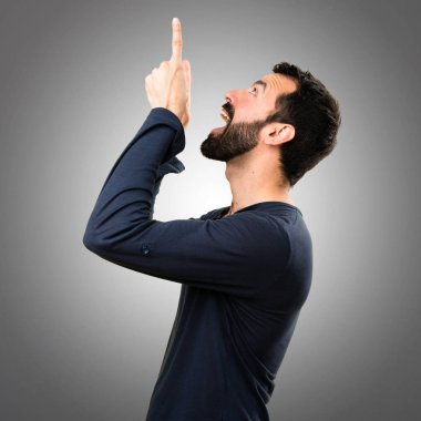 Gri arka plan üzerinde yukarıyı sakallı yakışıklı adam