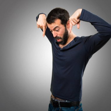 Sakal gri arka plan üzerinde aşağıyı ile yakışıklı adam