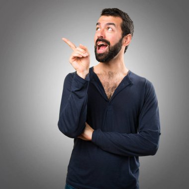 Gri arka planı sakalını düşünce ile yakışıklı adam