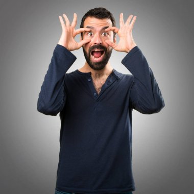 Bir şey gri arka plan üzerinde gösterilen sakallı yakışıklı adam