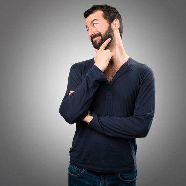 Gri arka plan üzerinde yanal seyir sakallı yakışıklı adam