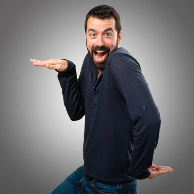 Gri arka plan üzerinde dans sakallı yakışıklı adam