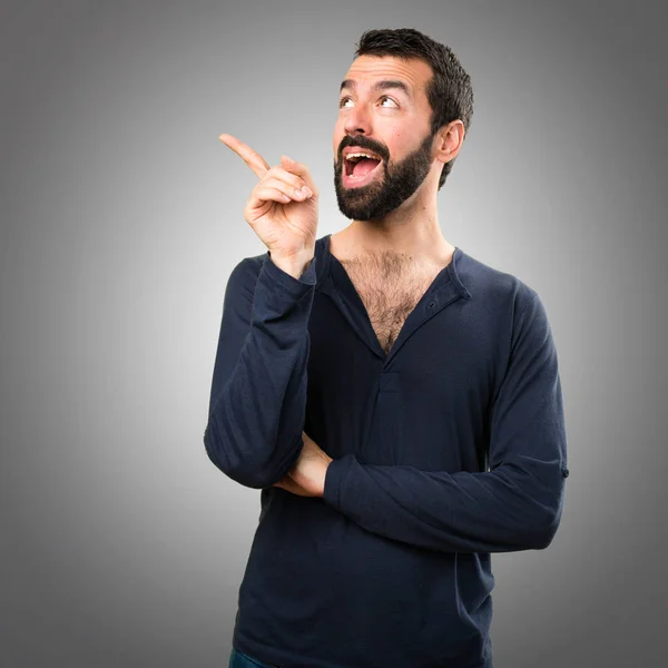 Pohledný muž s vousy myšlení na šedém pozadí — Stock fotografie