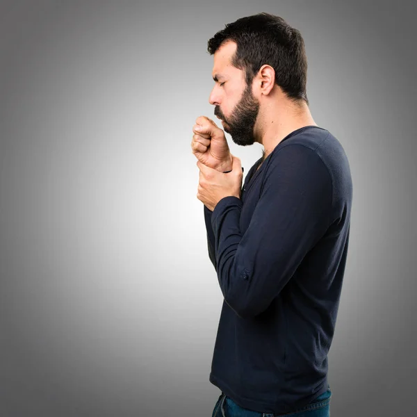 Pohledný muž s vousy kašlala na šedém pozadí — Stock fotografie