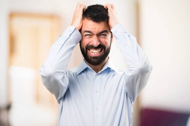 Sakallı odaklanmamış arka plan üzerinde hayal kırıklığına yakışıklı adam