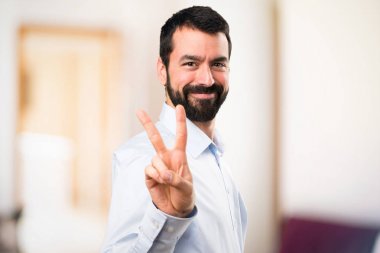 İki odaklanmamış arka plan üzerinde sayma sakallı yakışıklı adam