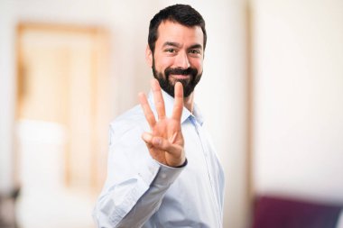 Üç odaklanmamış arka plan üzerinde sayma sakallı yakışıklı adam