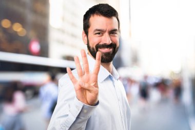 Dört odaklanmamış arka plan üzerinde sayma sakallı yakışıklı adam