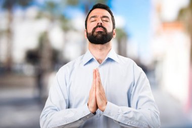 Zen pozisyonda odaklanmamış arka plan üzerinde sakallı yakışıklı adam