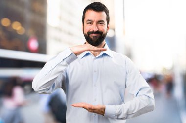 Bir şey üzerinde odaklanmamış adam tutarak sakallı yakışıklı adam