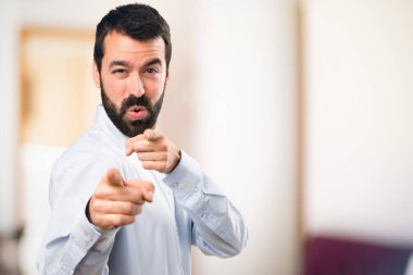 Ön yüzünde odaklanmamış backg işaret eden sakallı yakışıklı adam