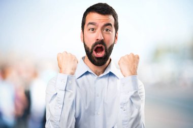 Sakallı odaklanmamış arka plan üzerinde şanslı yakışıklı adam