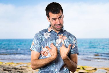 Plajda çiçek gömlek yapma sürpriz hareketi ile yakışıklı adam