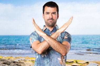 Plajda bir jest yapma çiçek forması ile yakışıklı adam