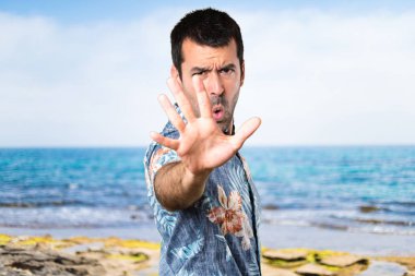 Dur işareti plajda yapma çiçek forması ile yakışıklı adam