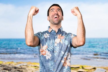 Plajda çiçek forması ile şanslı yakışıklı adam