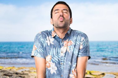 Plajda bir öpücük gönderme çiçek forması ile yakışıklı adam