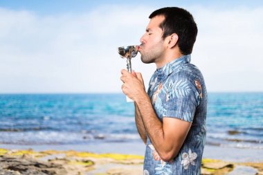 Bir kupa sahilde elinde çiçek forması ile yakışıklı adam