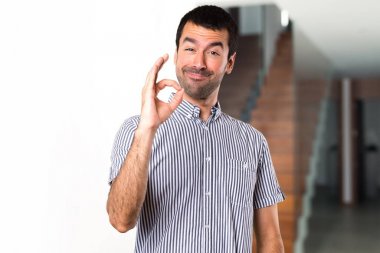 Yakışıklı adam evin içinde oturum Tamam yapma