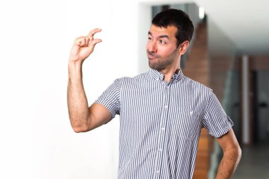 Yakışıklı adam evin içinde küçük işareti yapmak