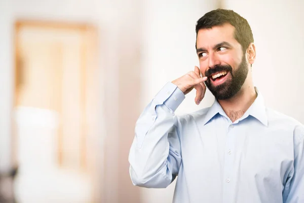 Bel homme avec barbe faisant geste de téléphone sur backgr non concentré — Photo