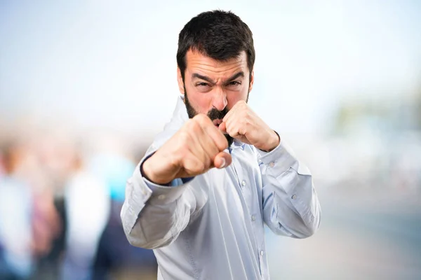 Hombre guapo con barba luchando sobre fondo desenfocado —  Fotos de Stock