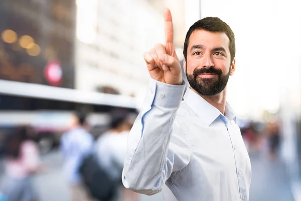 Schöner Mann mit Bart berührt auf transparentem Bildschirm auf unfocu — Stockfoto