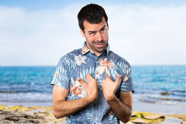 Plajda çiçek gömlek yapma sürpriz hareketi ile yakışıklı adam