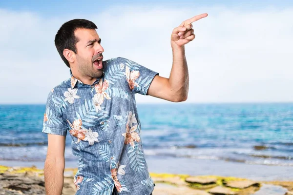Hombre guapo con camisa de flores bailando en la playa —  Fotos de Stock