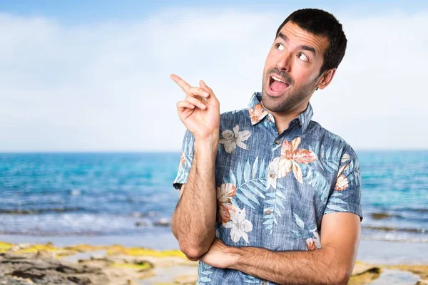 Hombre guapo con camisa de flores pensando en la playa —  Fotos de Stock