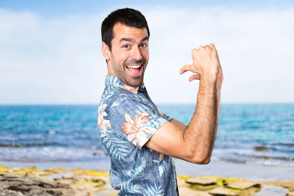 Hombre guapo con camisa de flores orgulloso de sí mismo en la playa —  Fotos de Stock