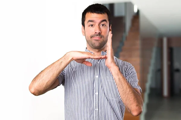 Handsome man making time out gesture inside house — Stock Photo, Image