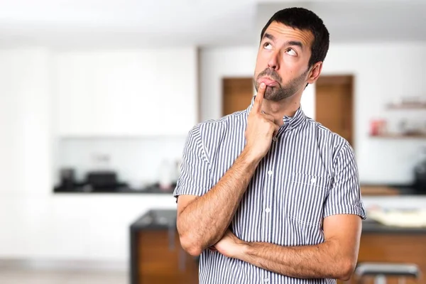 Bonito homem com dúvidas dentro de casa — Fotografia de Stock