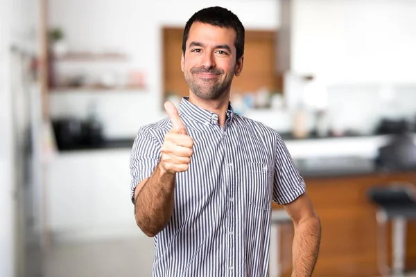 Bonito homem com polegar dentro de casa — Fotografia de Stock