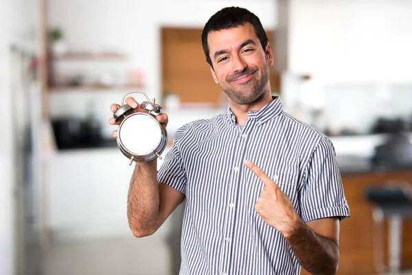 Vintage saat evin içinde tutan mutlu yakışıklı adam