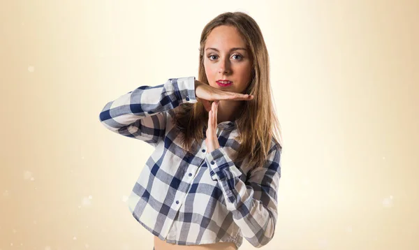 Blondes Teenie-Mädchen macht Auszeit Geste auf ockerfarbenem Hintergrund — Stockfoto