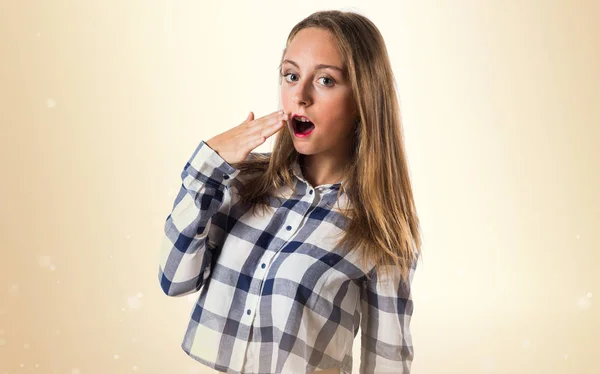 Loira adolescente menina bocejando no fundo ocre — Fotografia de Stock