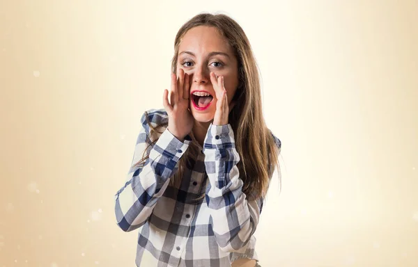 Blonde Teenager Mädchen schreit auf ockerfarbenem Hintergrund — Stockfoto